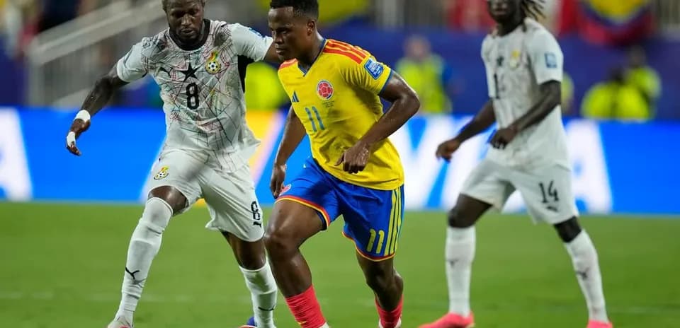 Jugador colombiano driblando a defensor ghanés en partido