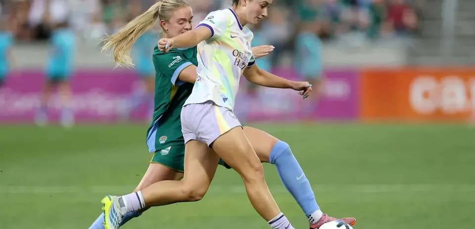 Una jugadora de Orlando Pride driblando a una rival
