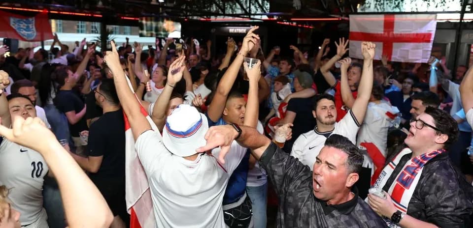 Aficionados celebrando en bar durante partido de fútbol