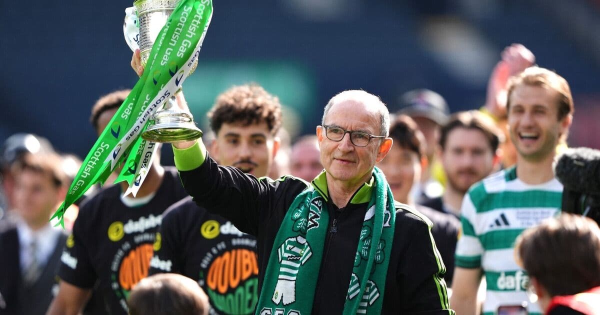 Entrenador levantando trofeo con jugadores sonrientes detrás