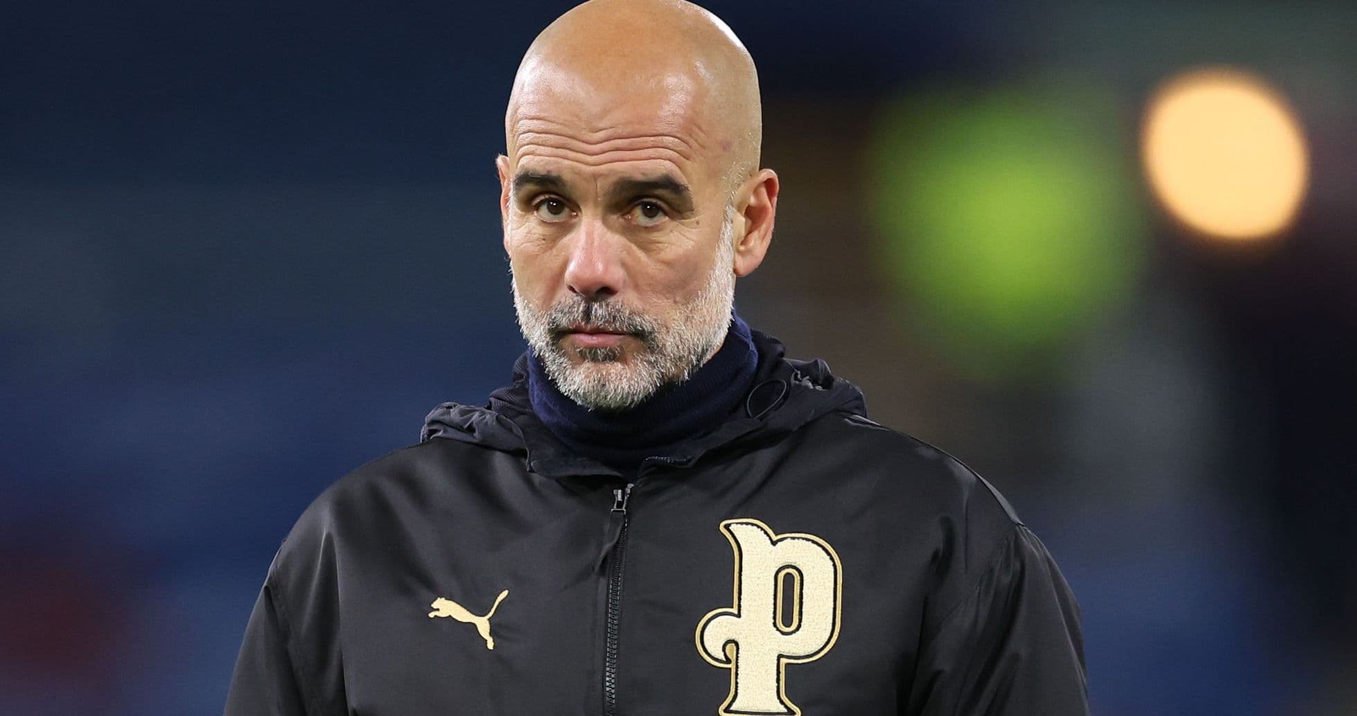 Entrenador con chaqueta negra observando el partido