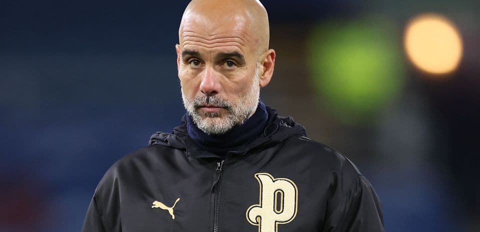 Entrenador con chaqueta negra observando el partido