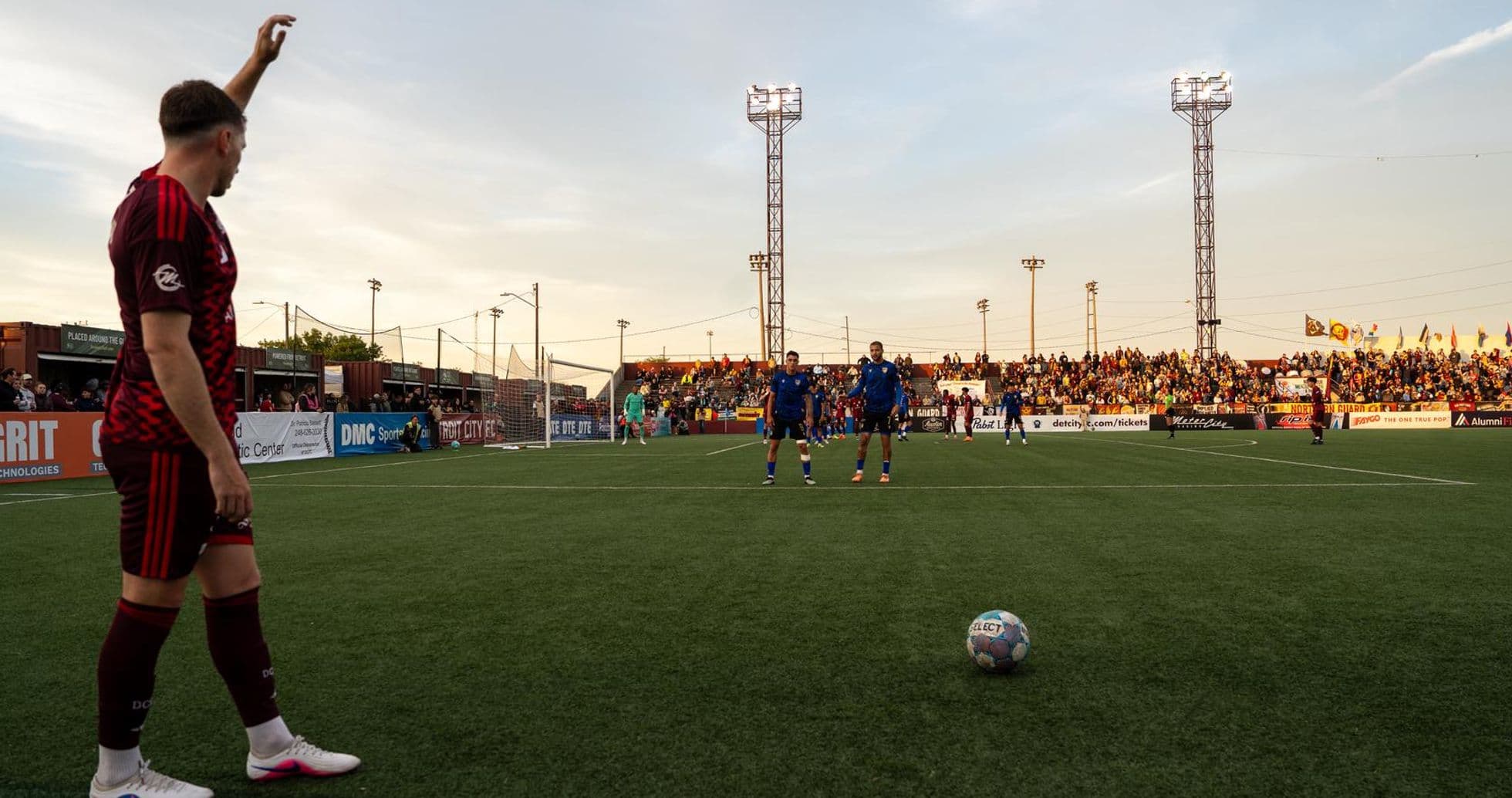 Jugador levantando la mano en un partido de fútbol