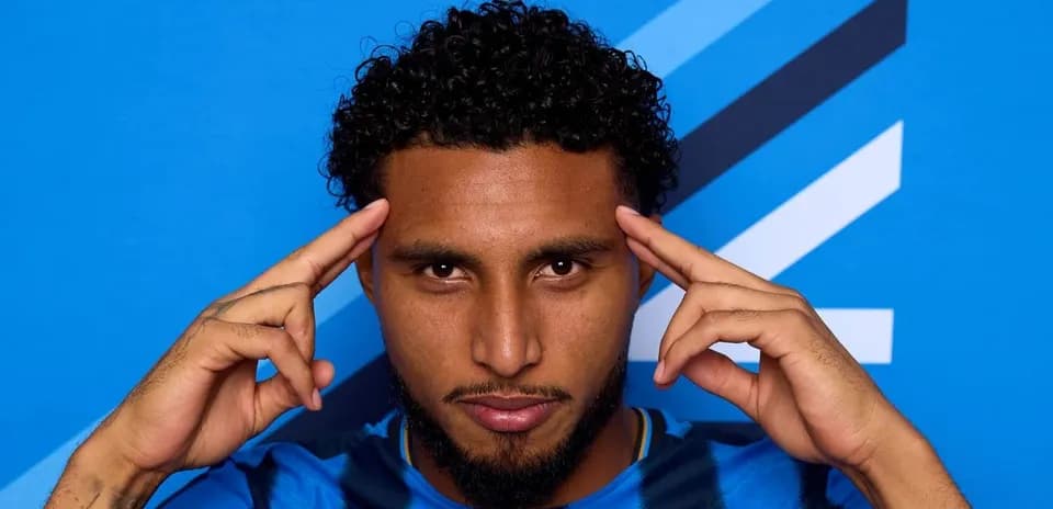 Jugador posando con fondo azul en camiseta azul