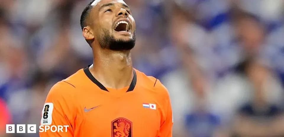 Jugador de fútbol en camiseta naranja mirando hacia arriba