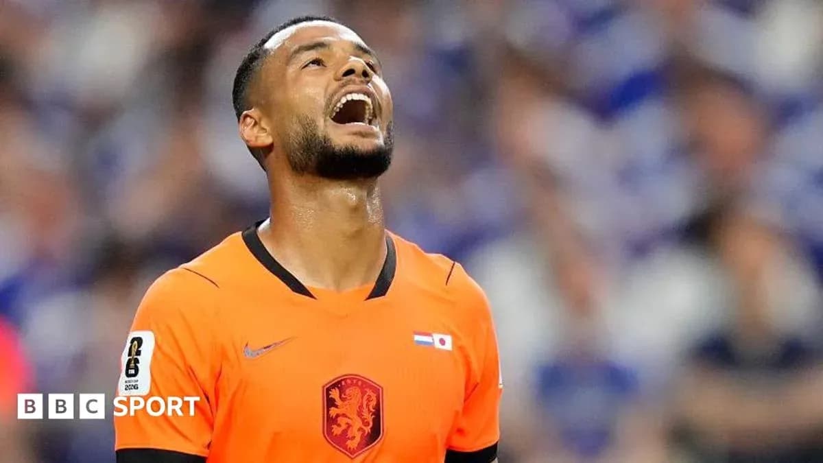 Jugador de fútbol en camiseta naranja mirando hacia arriba