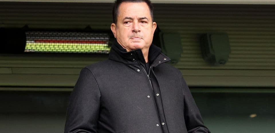 Hombre en abrigo negro en un palco de estadio