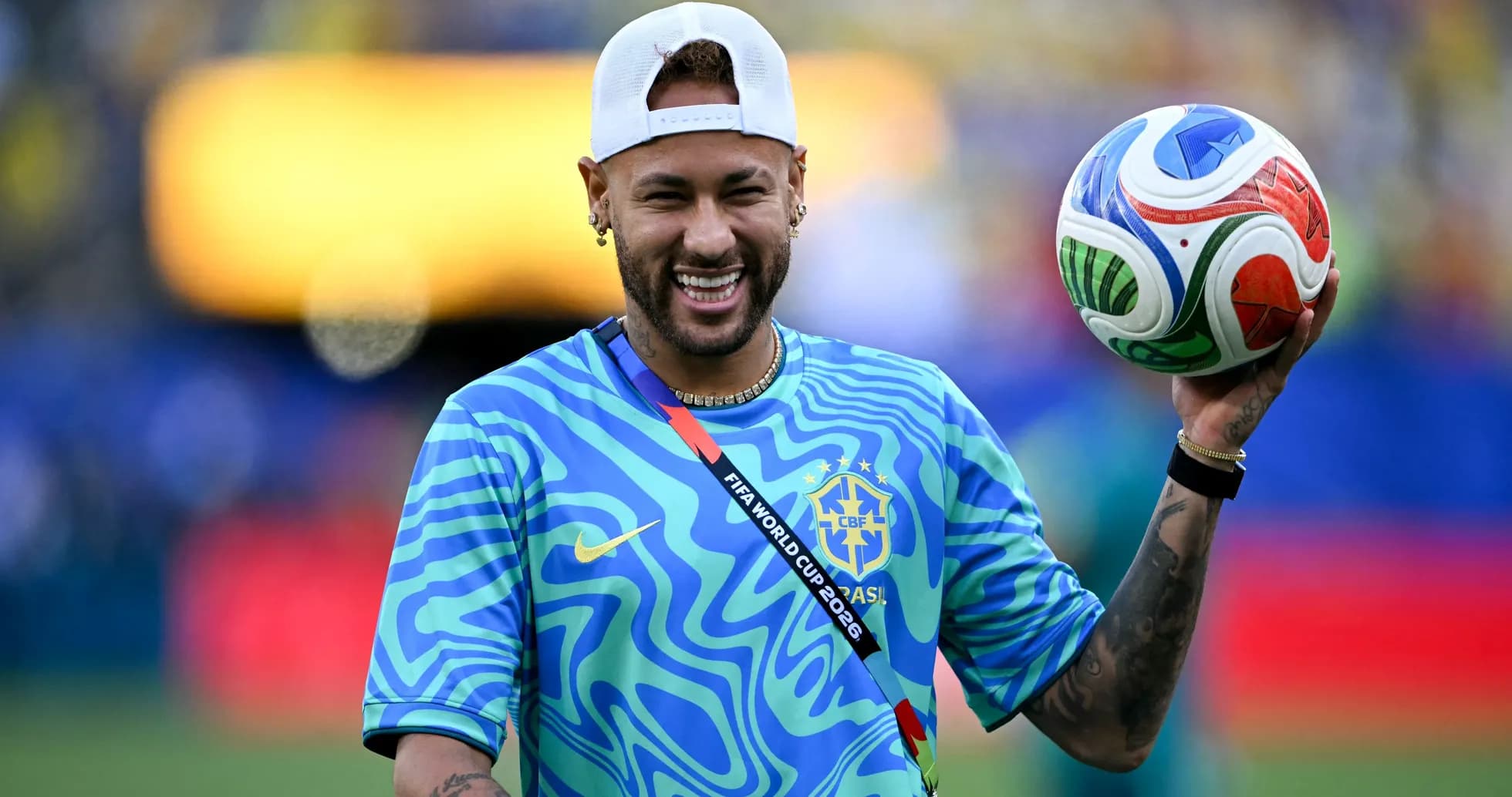 Neymar sosteniendo un balón de fútbol en el campo