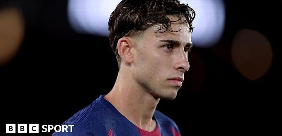Jugador de fútbol en uniforme de Barcelona mirando pensativo