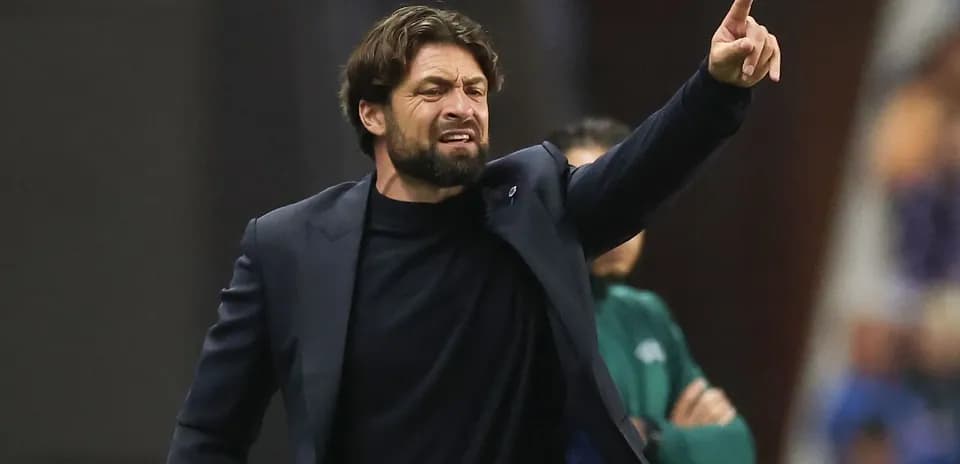 Entrenador dirigiendo instrucciones desde la línea de banda