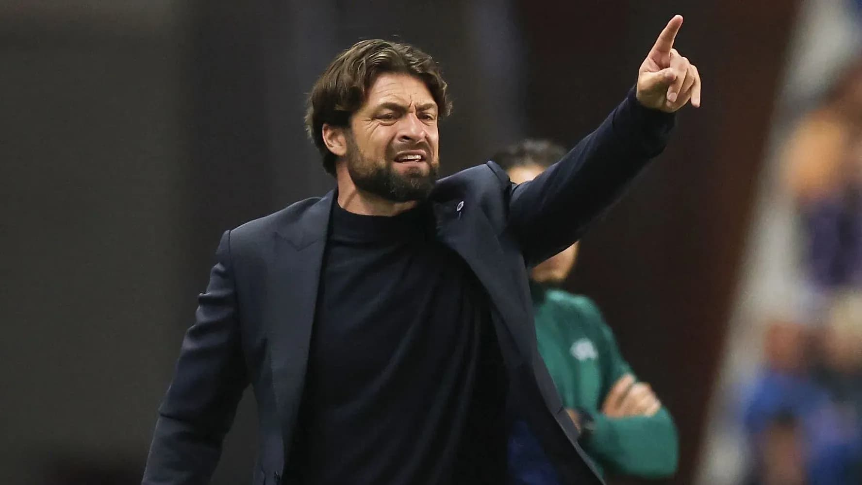 Entrenador dirigiendo instrucciones desde la línea de banda