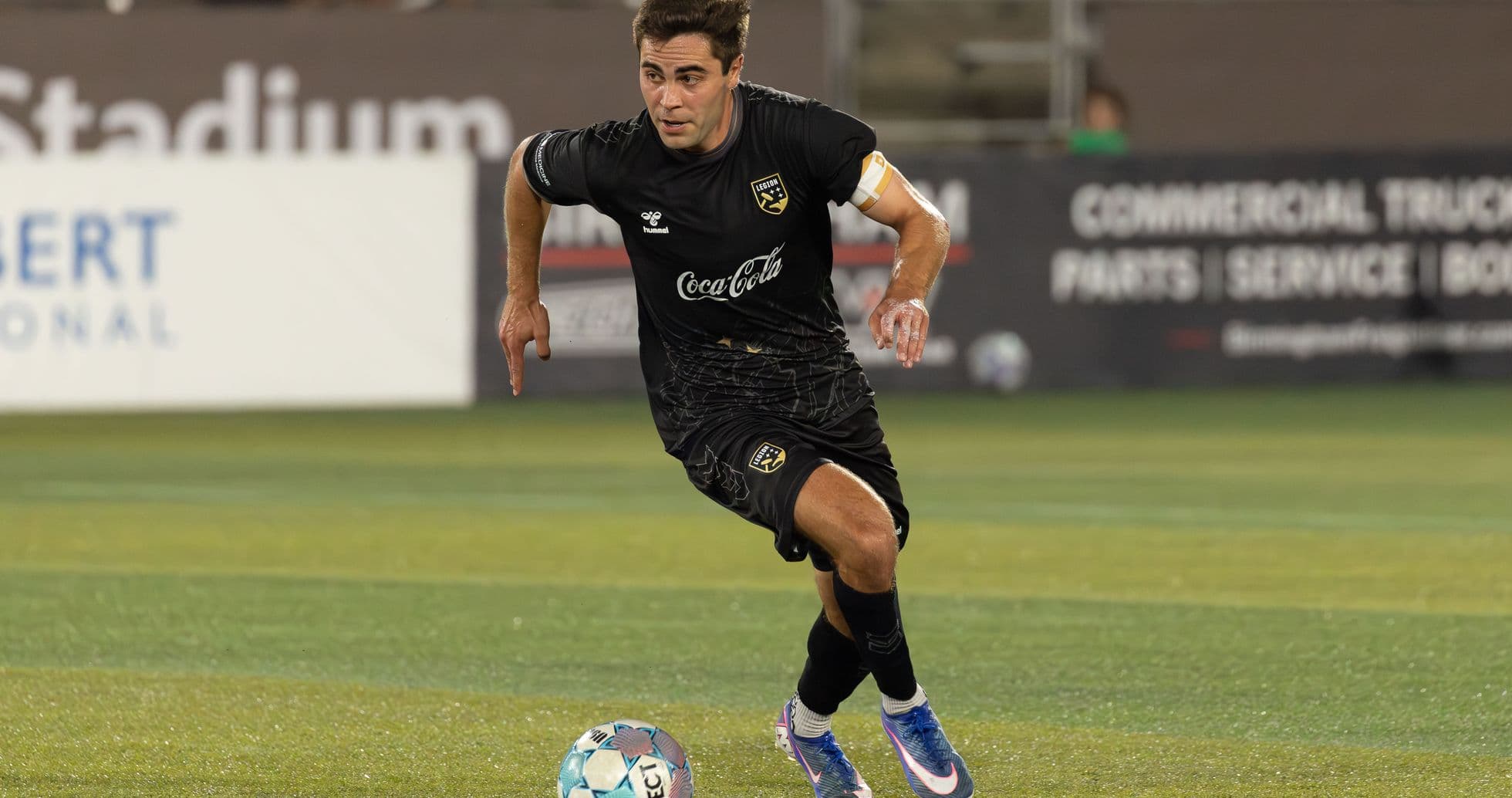 Jugador corriendo con balón en el campo