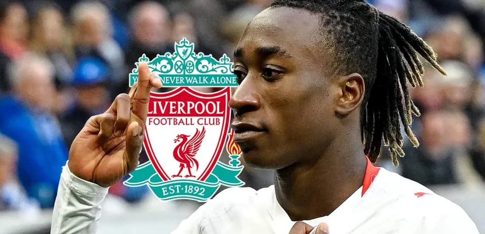 Jugador de fútbol señalando el logo de Liverpool