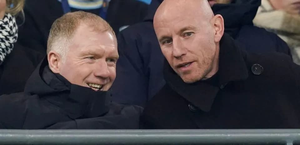Dos hombres conversando en un partido de fútbol