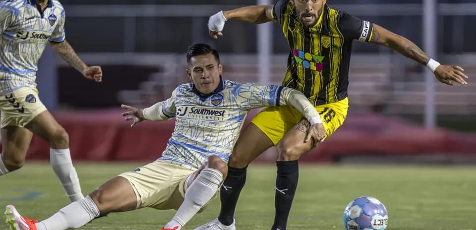 Jugadores compiten por el balón en el partido