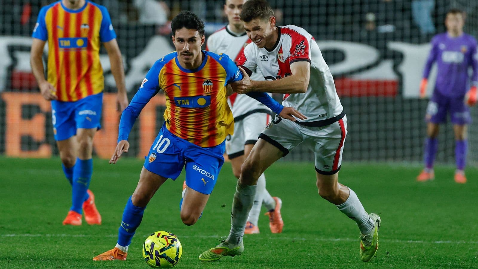 Jugador de Valencia driblando a oponente de Rayo Vallecano