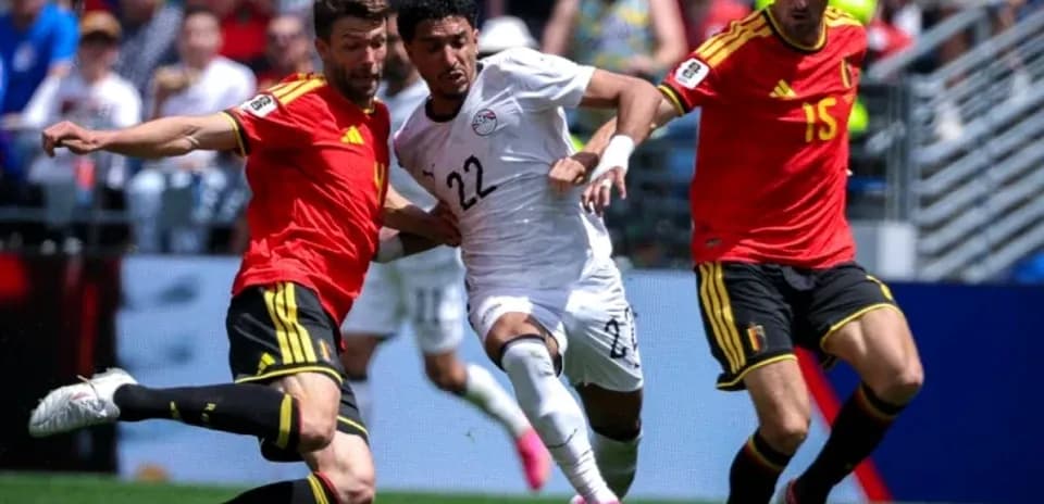 Jugador de Egipto esquivando a dos defensores de Bélgica