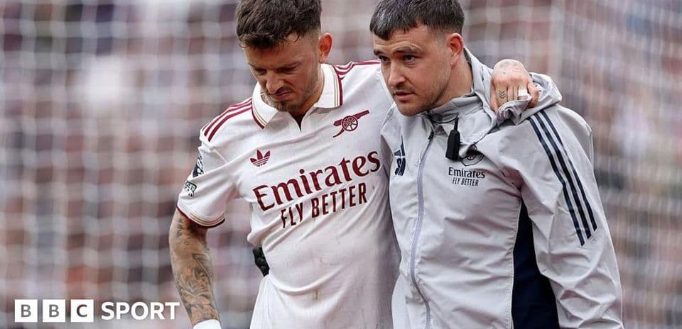 Jugador de Arsenal siendo ayudado por un miembro del personal