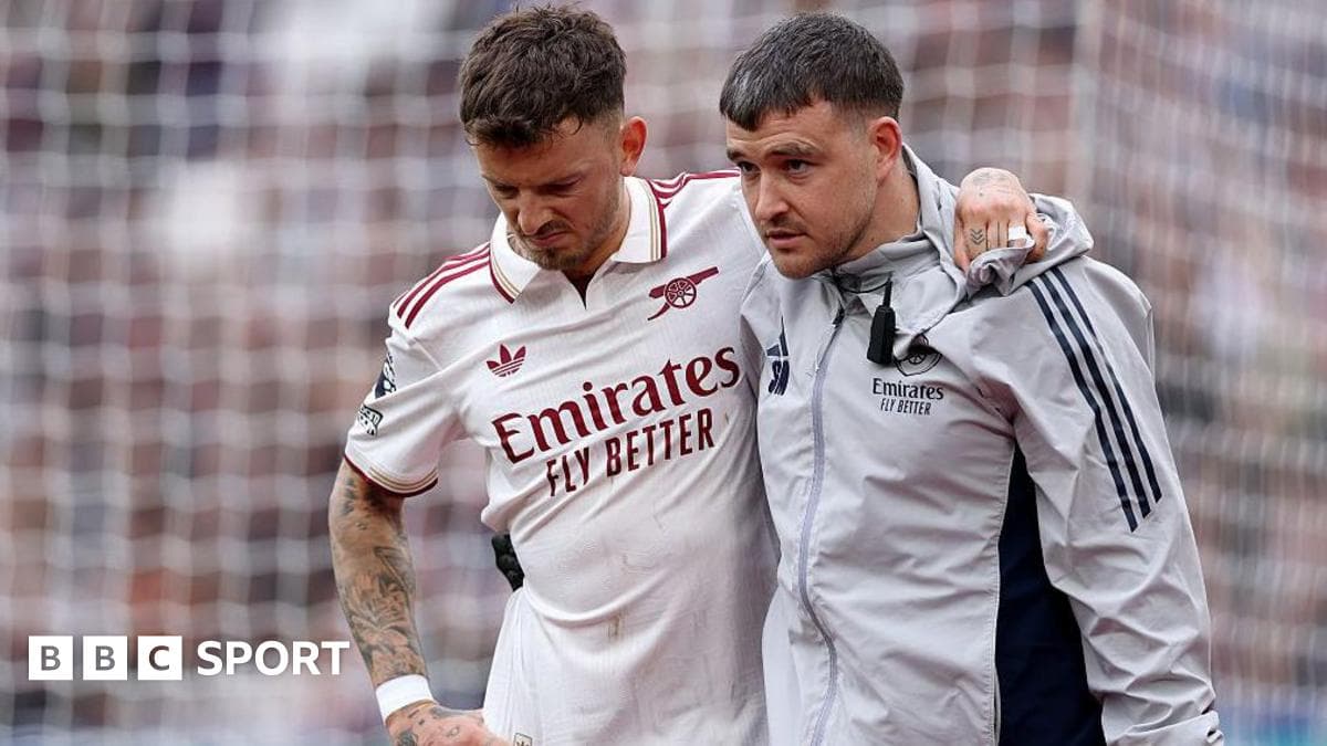 Jugador de Arsenal siendo ayudado por un miembro del personal