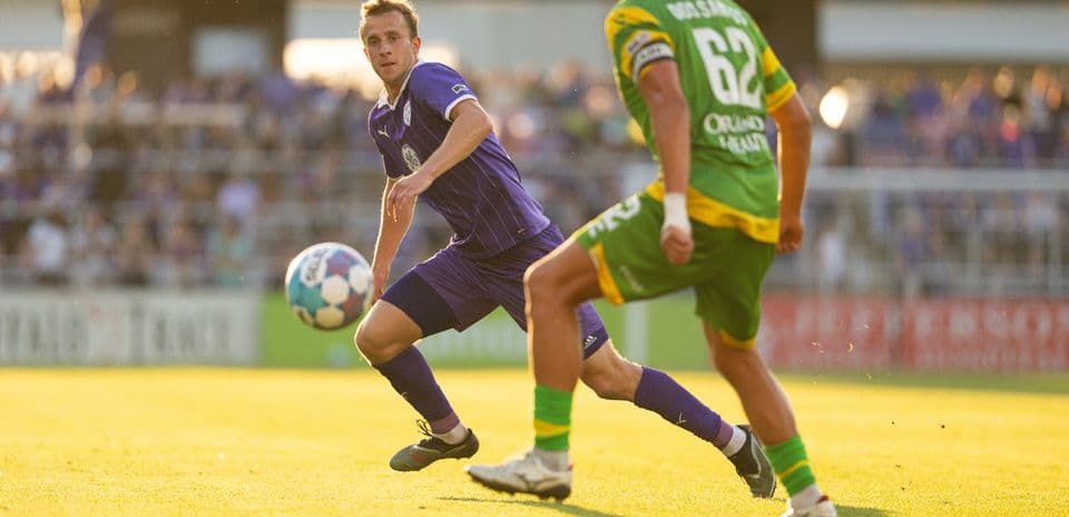 Jugador de Louisville City pasando el balón