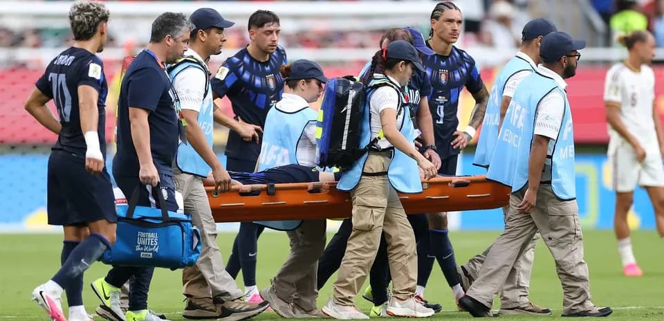Jugadores observando a compañero en camilla médica
