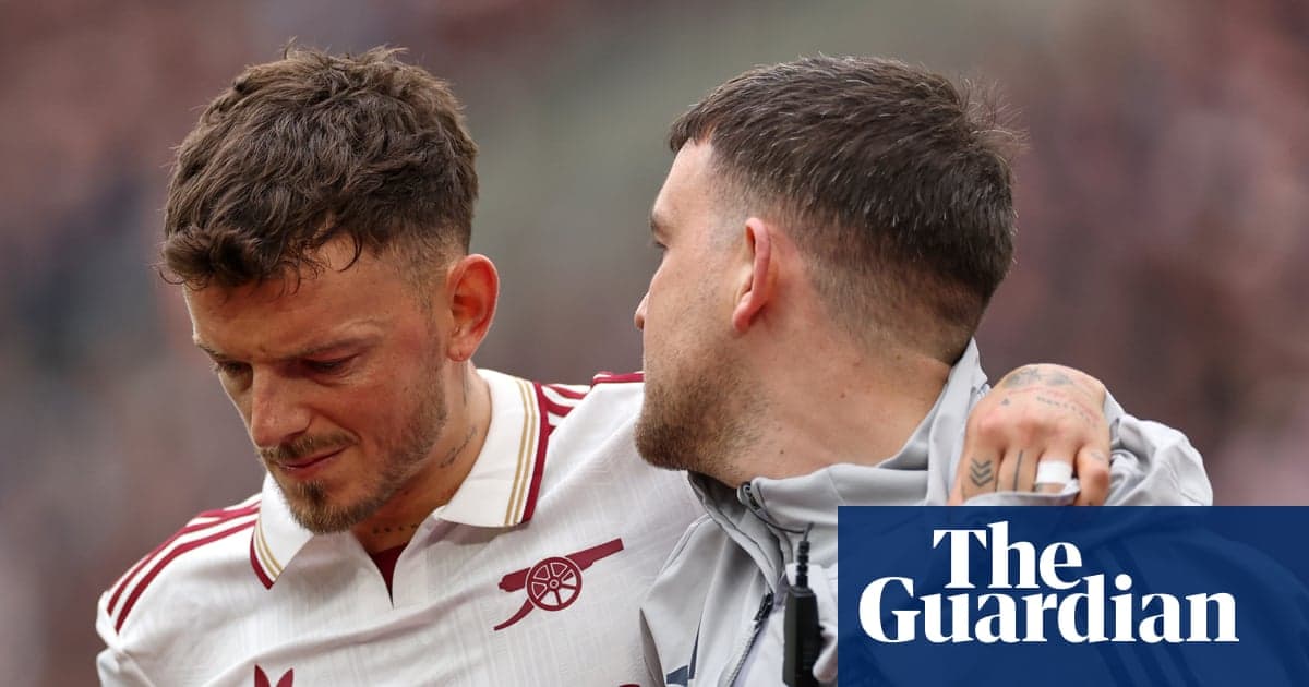 Jugador de Arsenal siendo ayudado por compañero