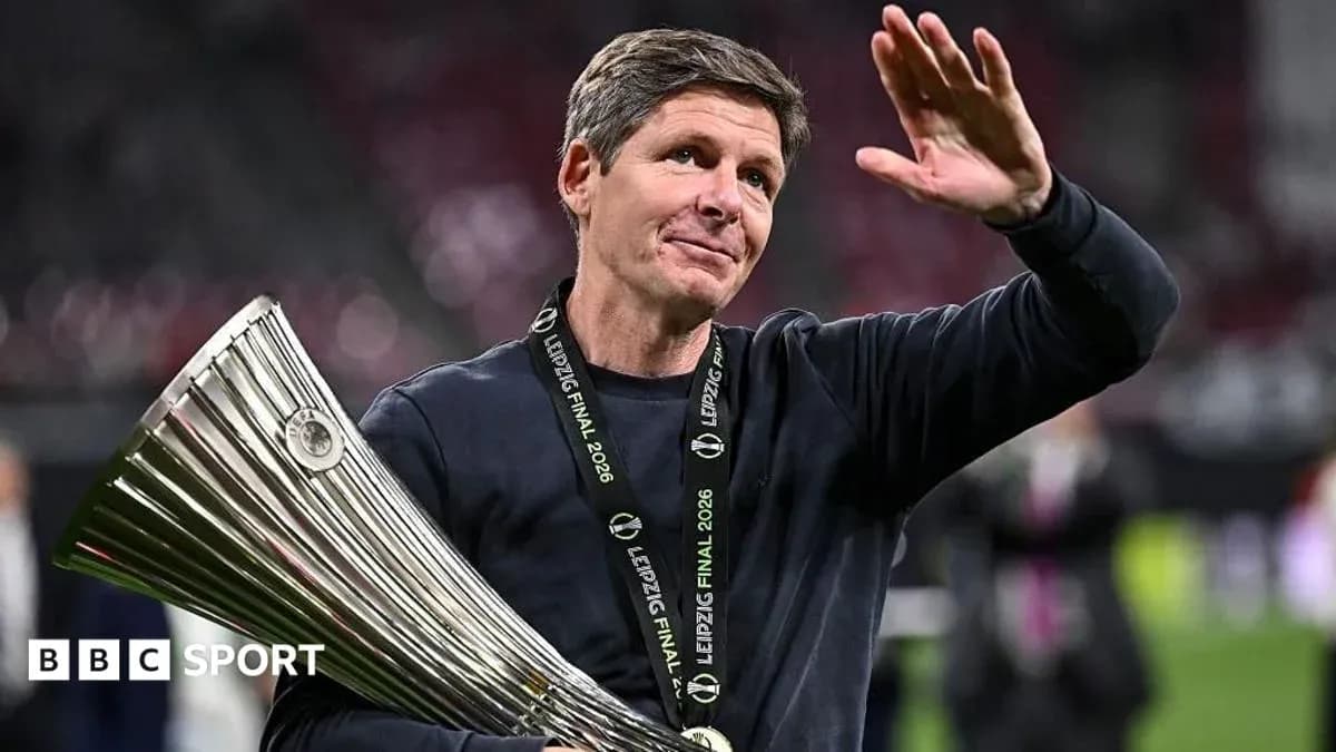 Entrenador sosteniendo trofeo y saludando al público