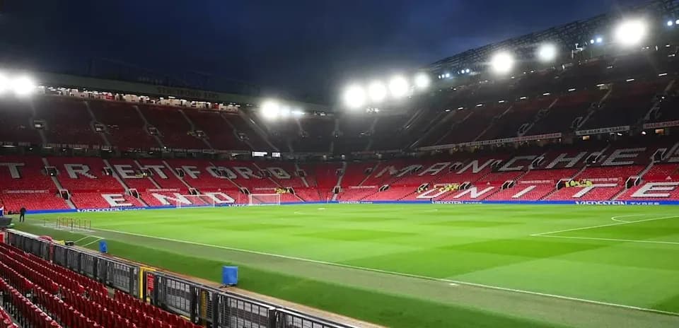 Estadio Old Trafford con asientos vacíos y césped