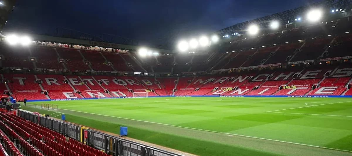 Estadio Old Trafford con asientos vacíos y césped