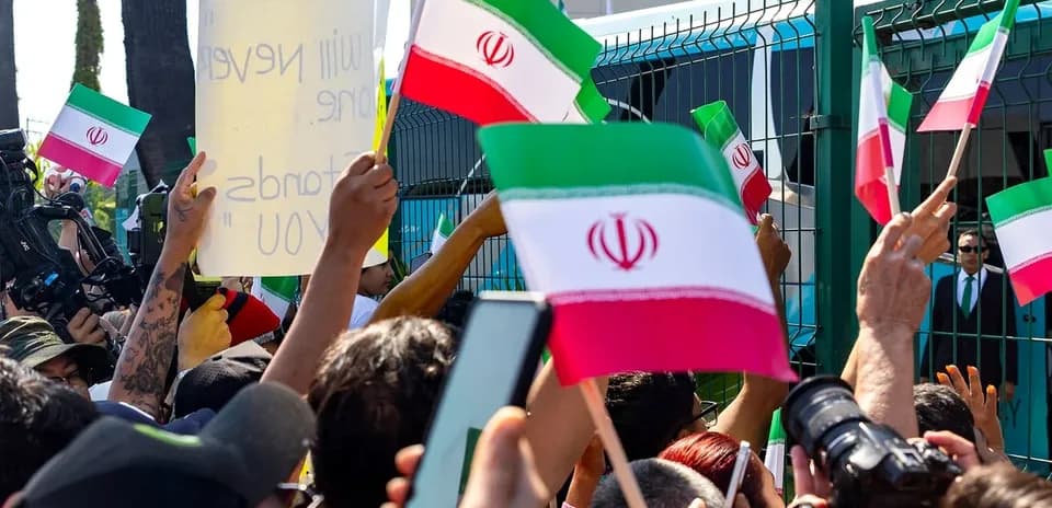 Multitud sosteniendo banderas de Irán en protesta