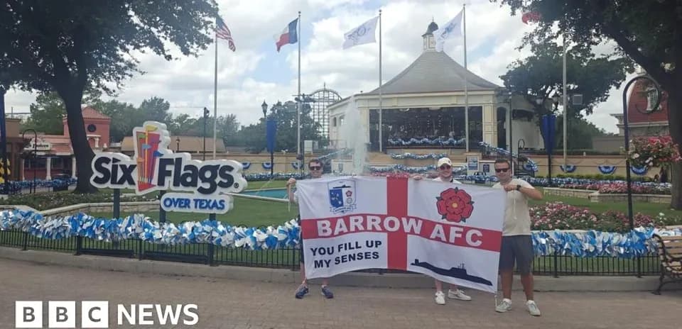 Dos personas sosteniendo una bandera de Barrow AFC en Six Flags
