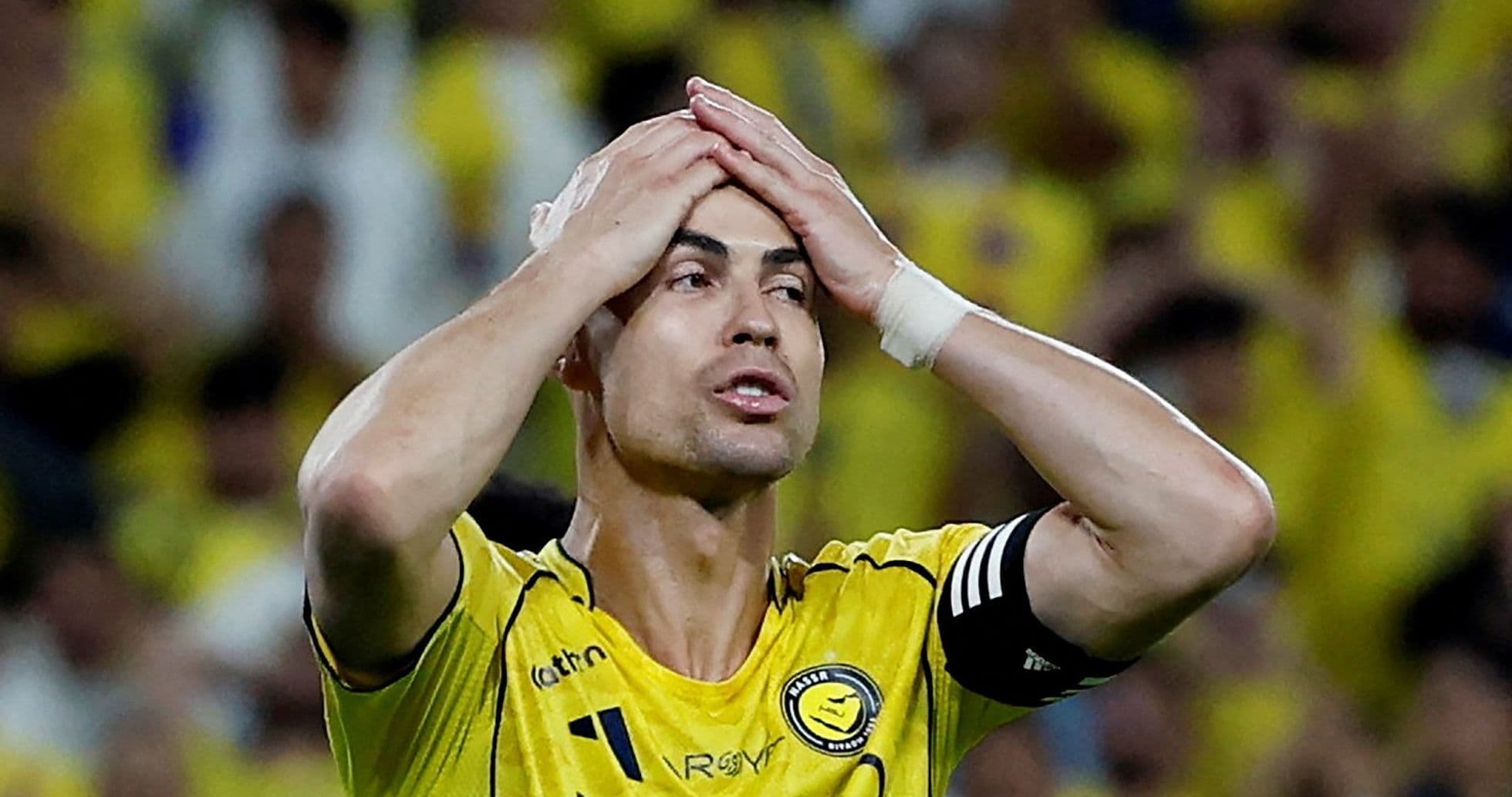 Jugador con camiseta amarilla sosteniendo la cabeza en partido