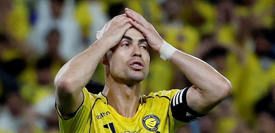 Jugador con camiseta amarilla sosteniendo la cabeza en partido