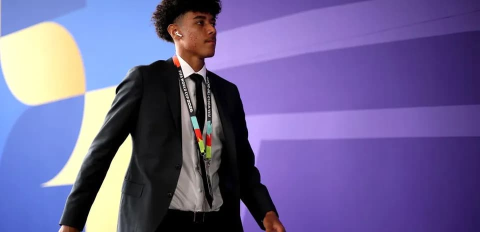 Jugador caminando con traje y distintivo de FIFA