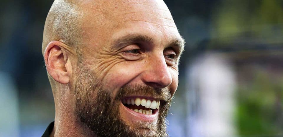 Hombre sonriendo en un entorno deportivo