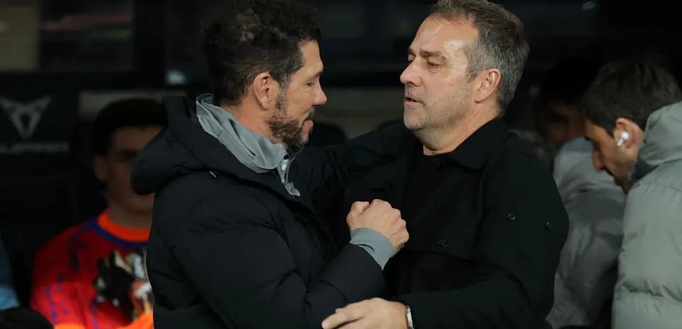 Entrenadores saludándose en el banquillo durante partido