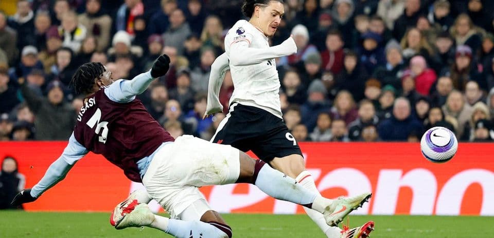 Jugador de Liverpool esquivando a defensor de Aston Villa