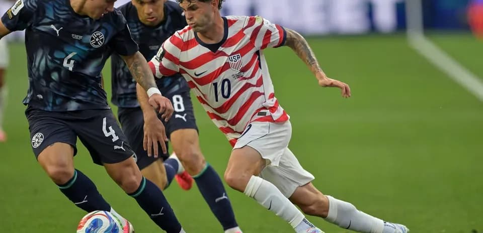 Jugador de Estados Unidos driblando a defensores paraguayos