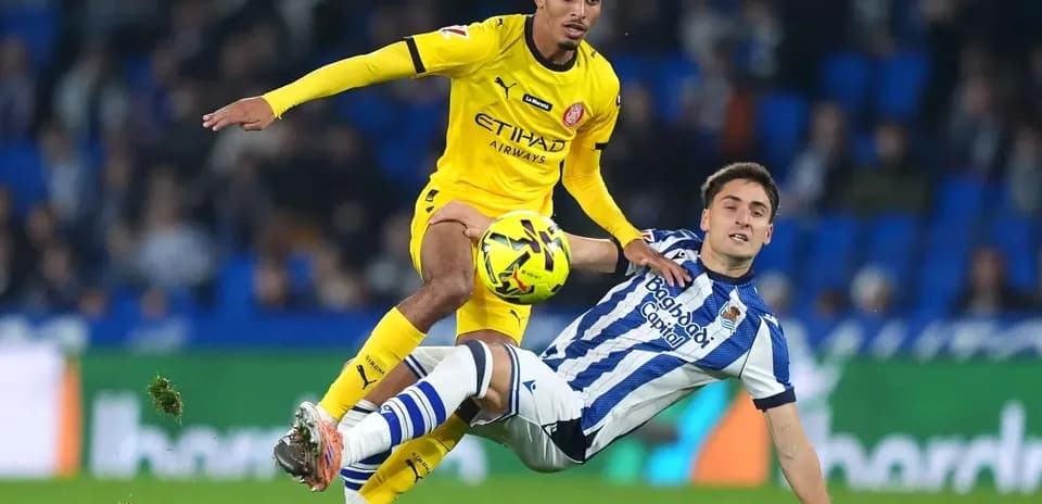 Jugador de Girona desafiando a rival de Real Sociedad