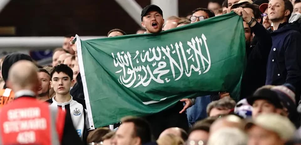 Afanático sostiene una bandera de Arabia Saudita en el estadio
