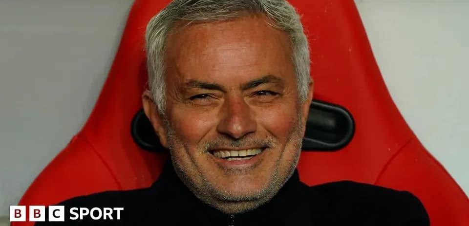 Entrenador sentado en banco de suplentes sonriendo