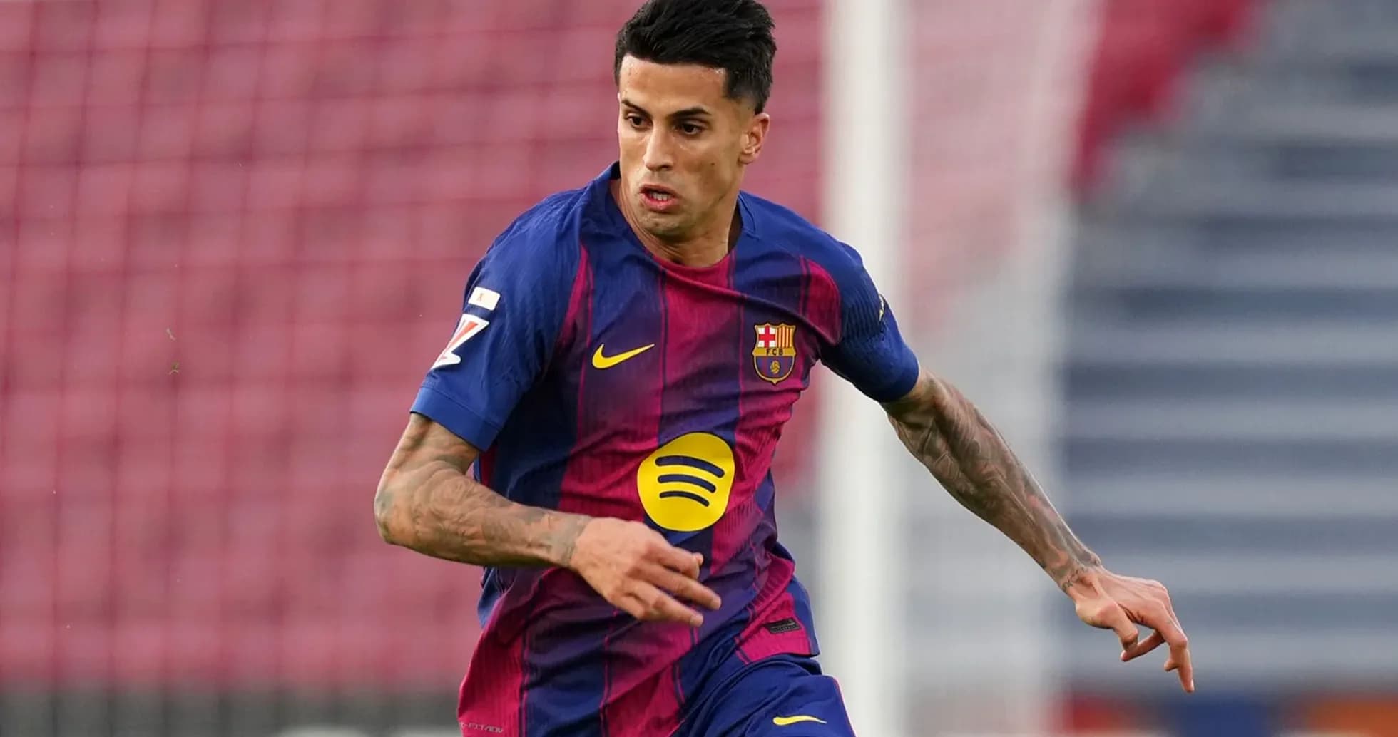 Jugador de Barcelona corriendo con balón en el campo