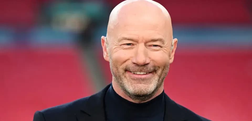Hombre con chaqueta negra sonriendo en el estadio