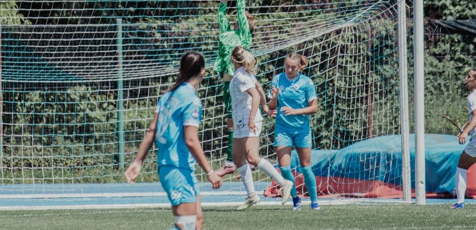 Portera atrapando el balón en el partido