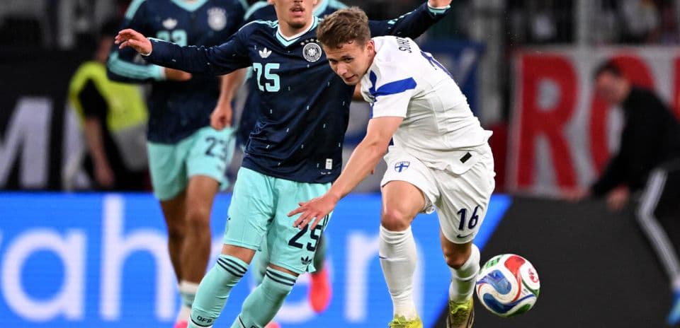 Jugador de Finlandia despojando balón a rival alemán