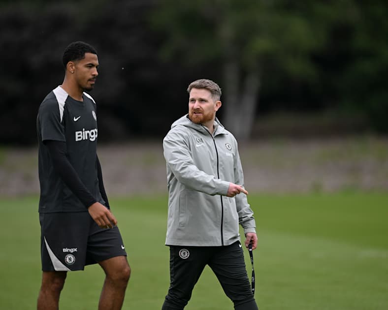 Jugador y entrenador conversando en campo de entrenamiento Jugador y entrenador conversando en campo de entrenamiento