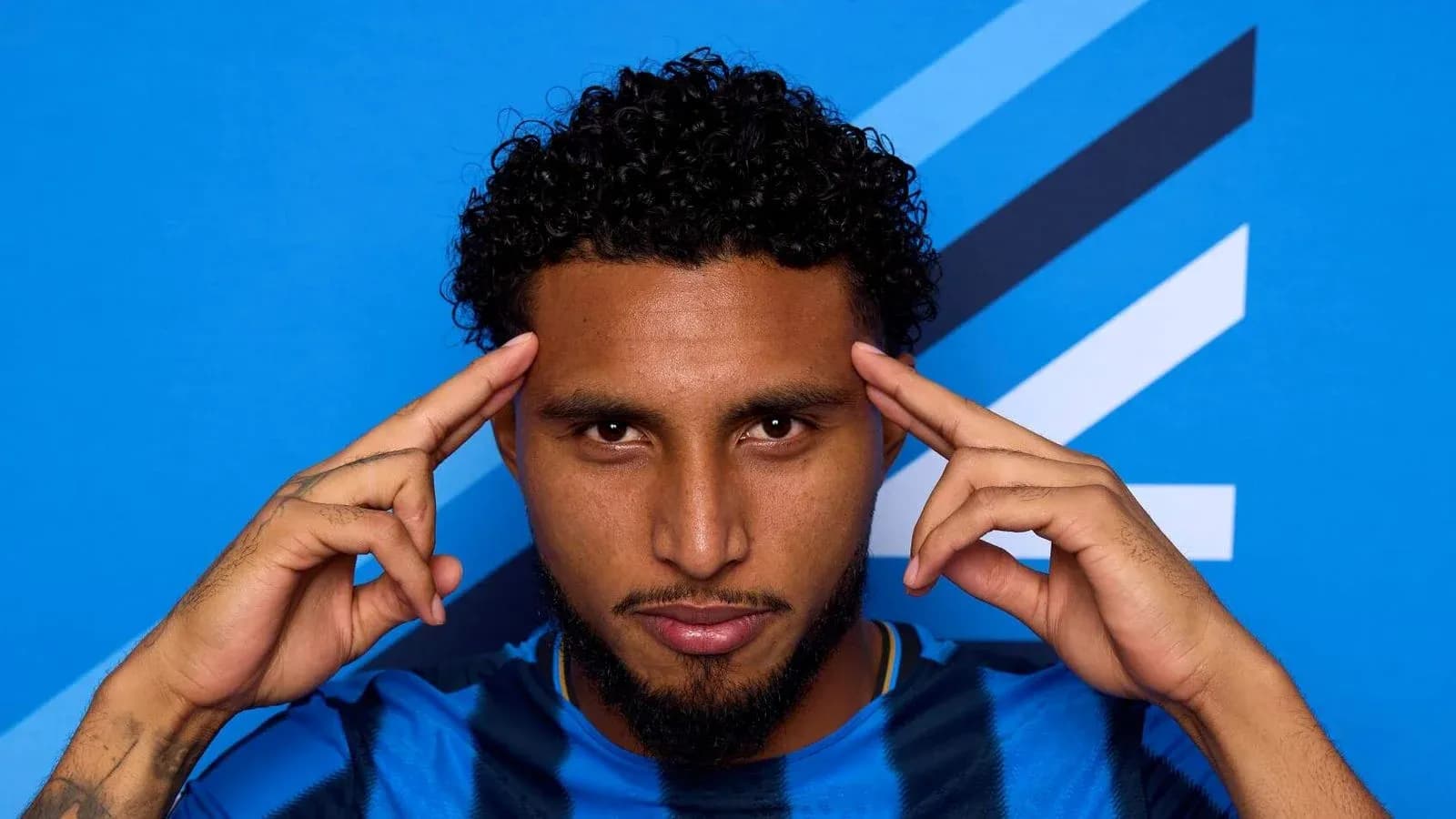 Jugador posando con fondo azul en camiseta azul Jugador posando con fondo azul en camiseta azul
