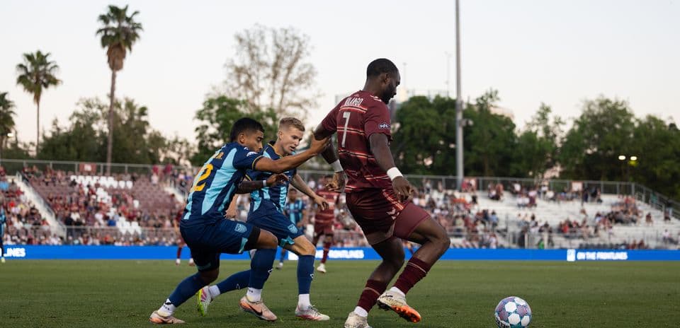 Dos jugadores persiguiendo el balón en el partido Dos jugadores persiguiendo el balón en el partido