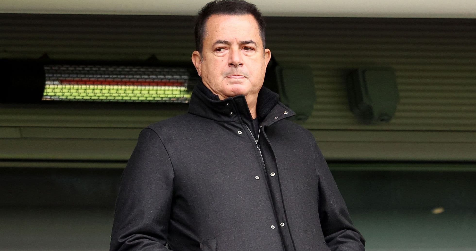 Hombre en abrigo negro en un palco de estadio Hombre en abrigo negro en un palco de estadio