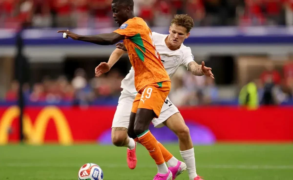 Jugador con camiseta naranja driblando a oponente Jugador con camiseta naranja driblando a oponente